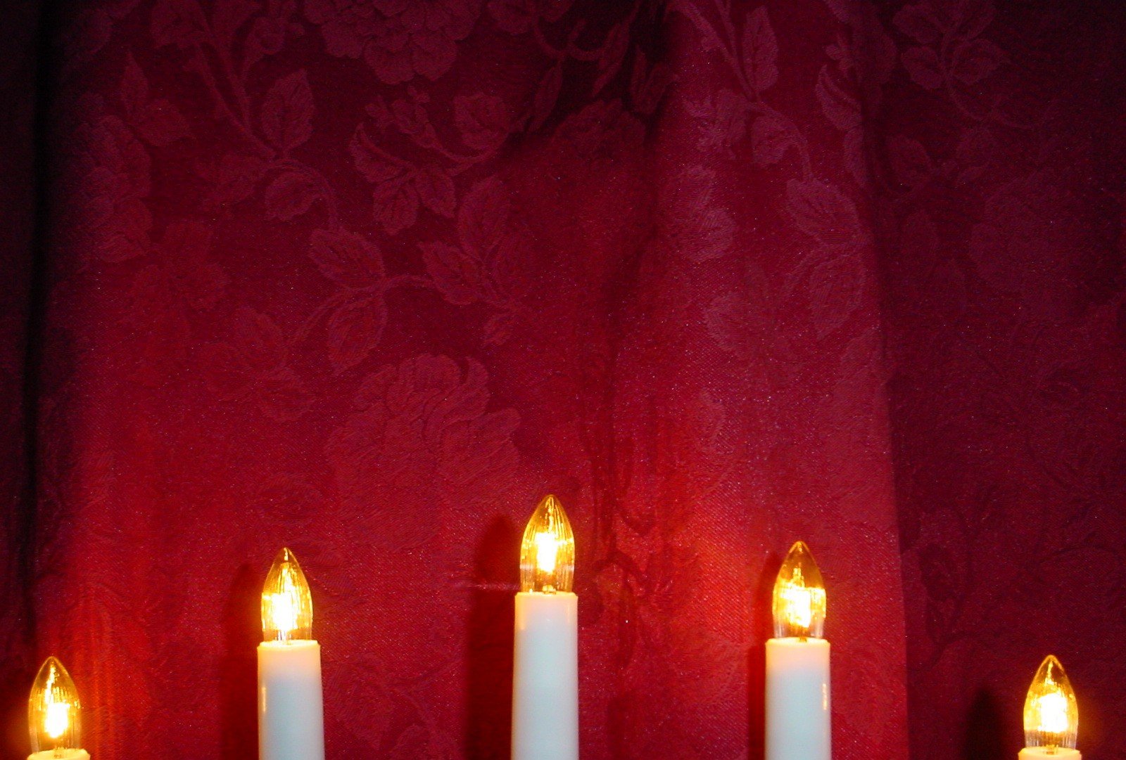 the candles are in rows against the red background