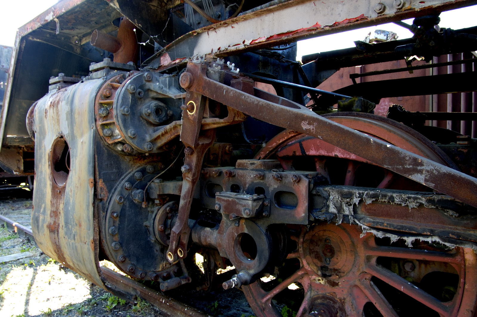 an old, rusted locomotive sits on some grass
