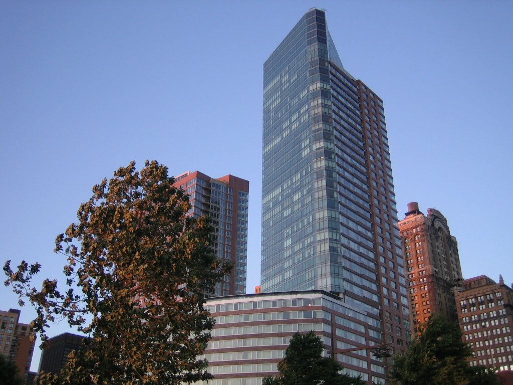 tall buildings with trees in the foreground and blue sky