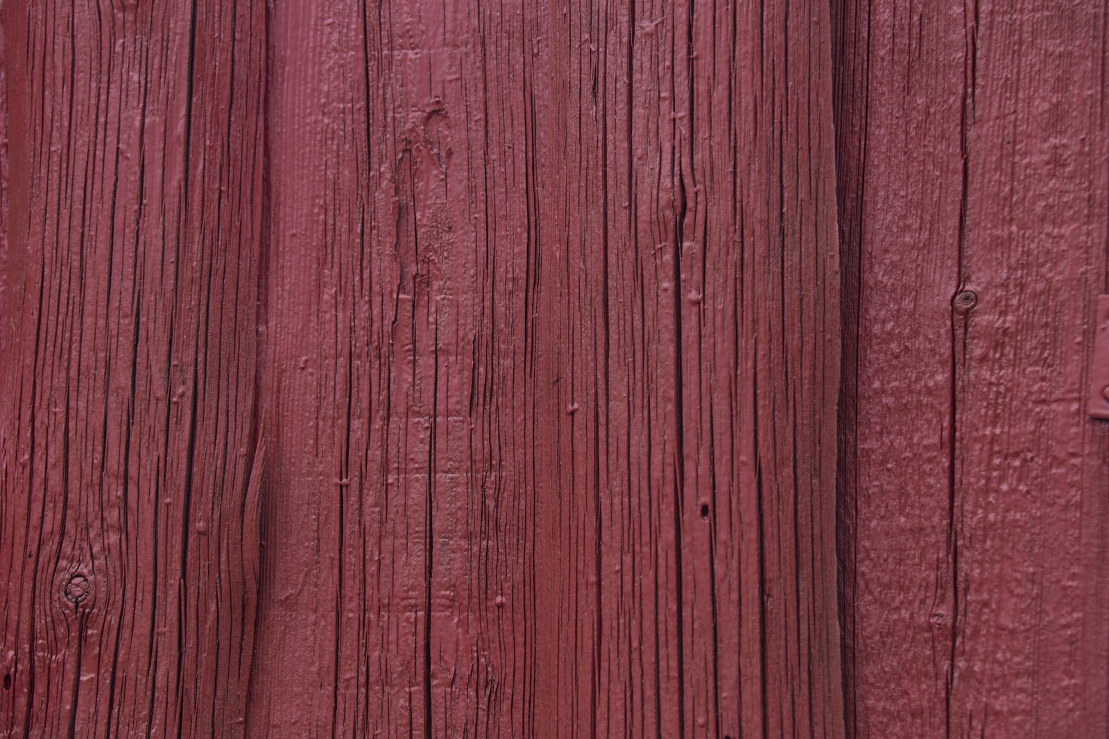 a red phone sitting on top of a wooden fence