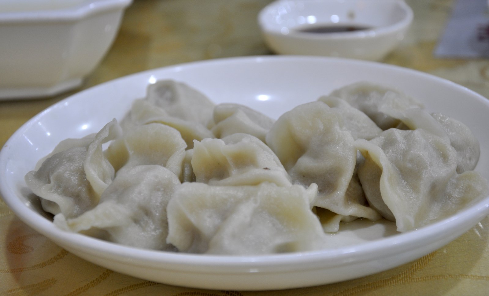 a white bowl full of dumplings on a table