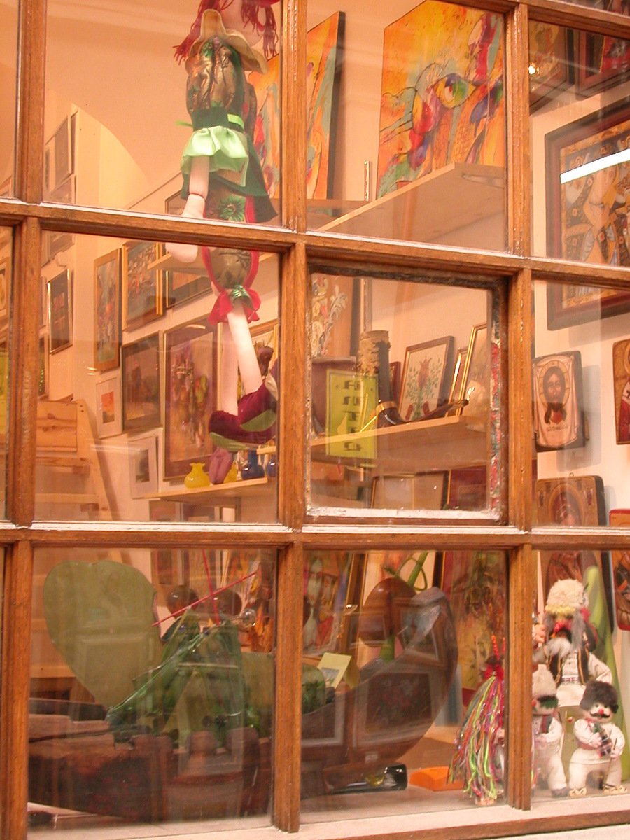 a glass display case with dolls, teddy bears and other items