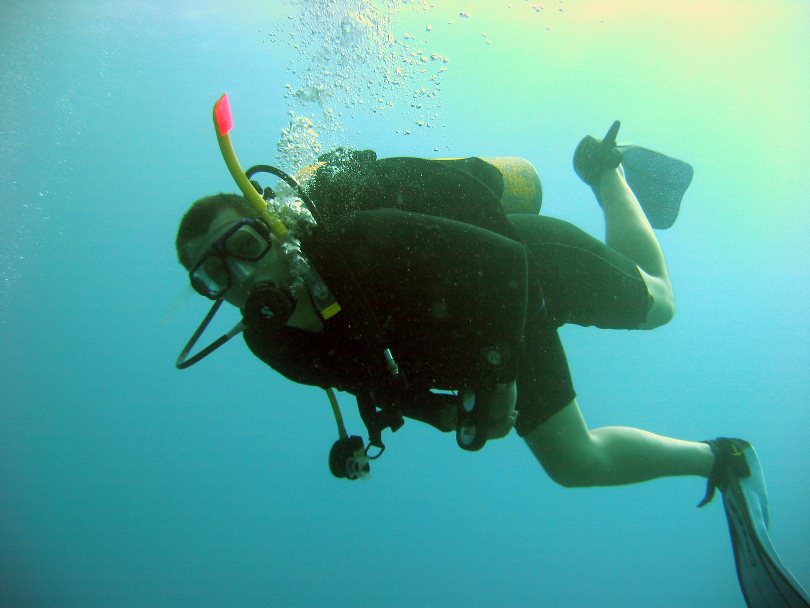 a scuba diver in the water with his legs on the edge of the water