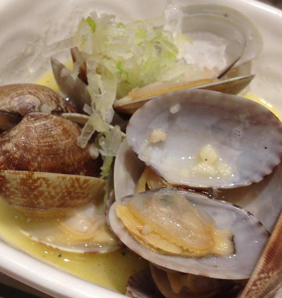 fresh clams cooked in a white bowl with ice tea