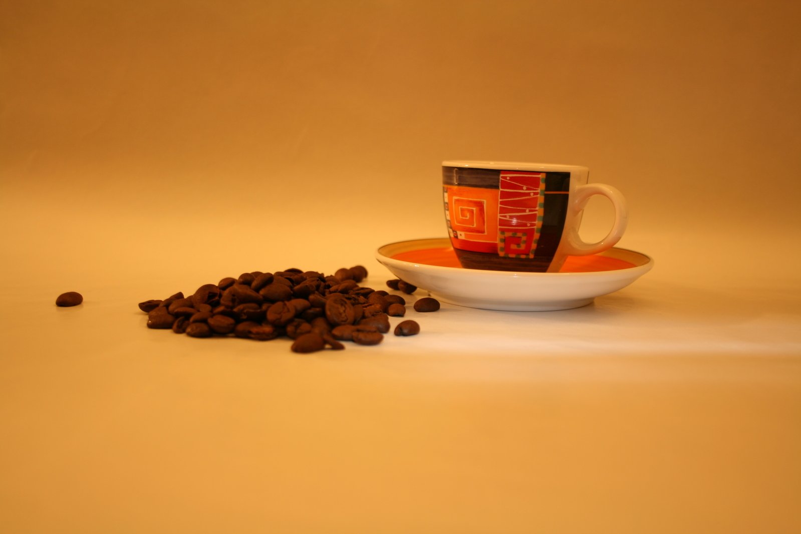 coffee beans spilled in front of a cup of coffee