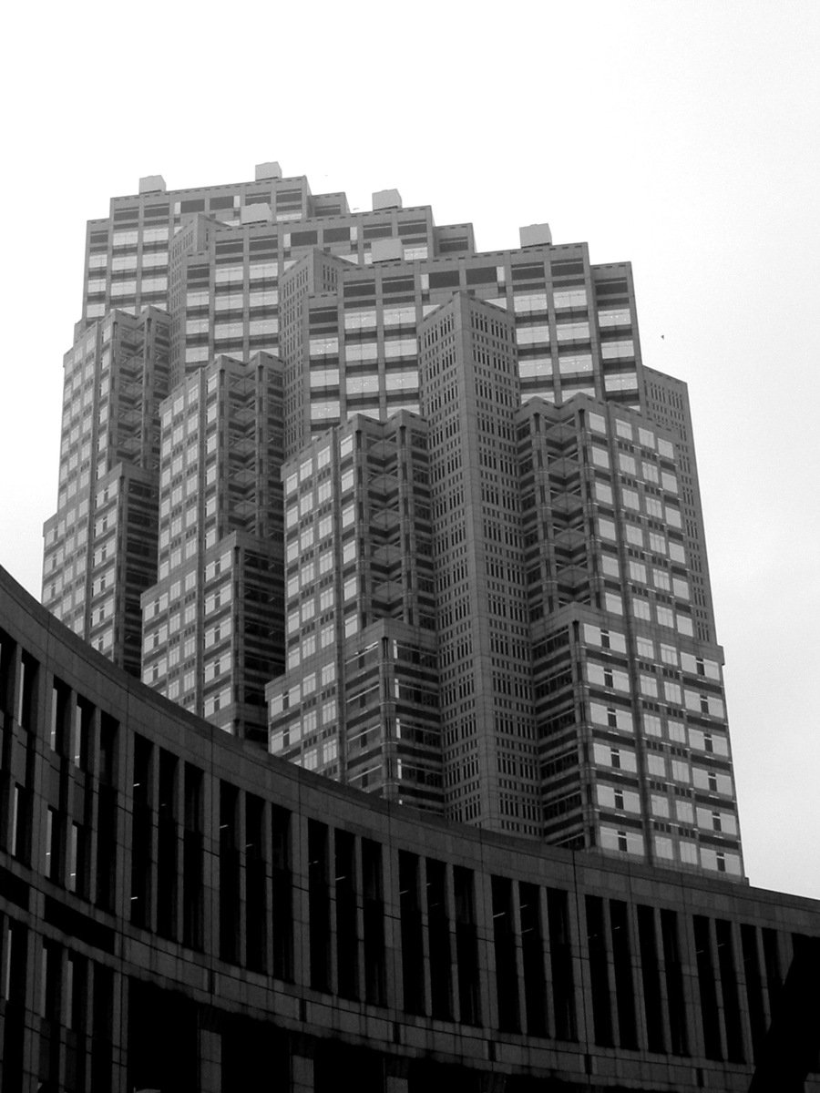 an angled view of two tall buildings under a cloudy sky