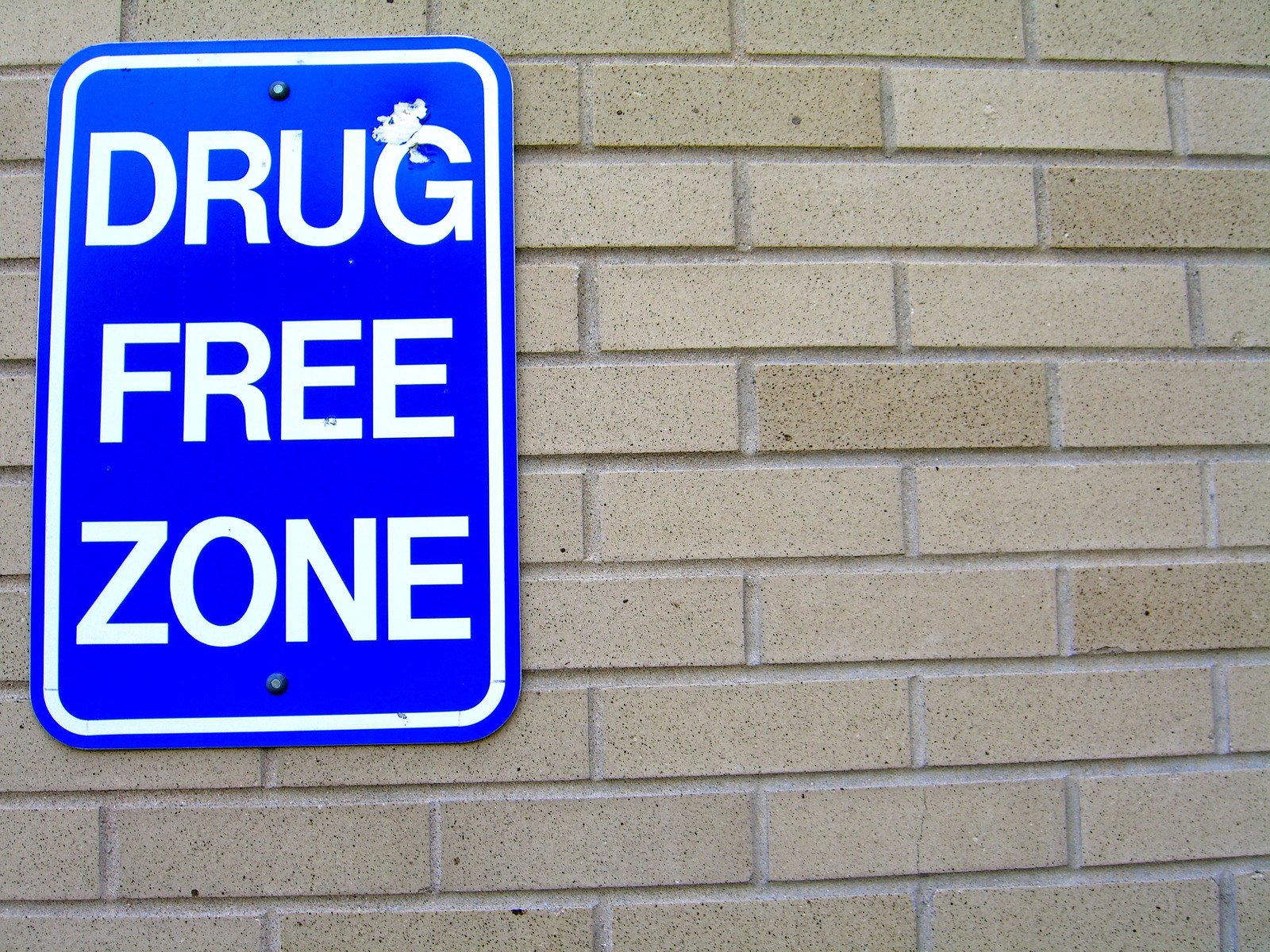the blue sign is for drug free zone on a wall