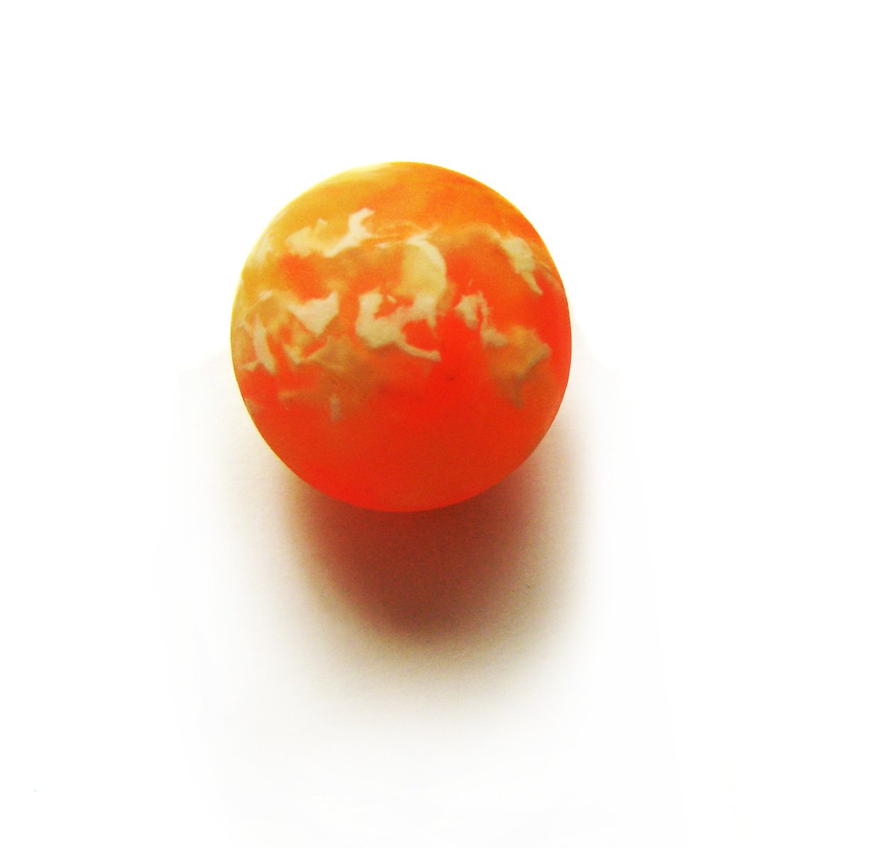an orange piece of fruit on a white surface