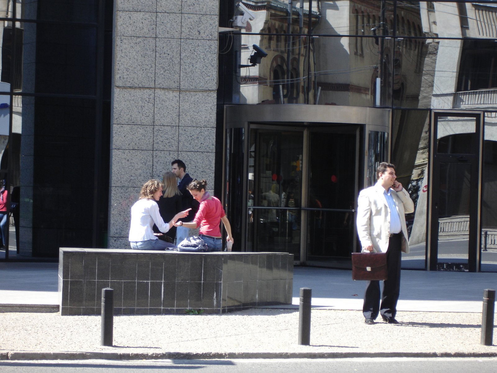 a man and three people standing around outside a building