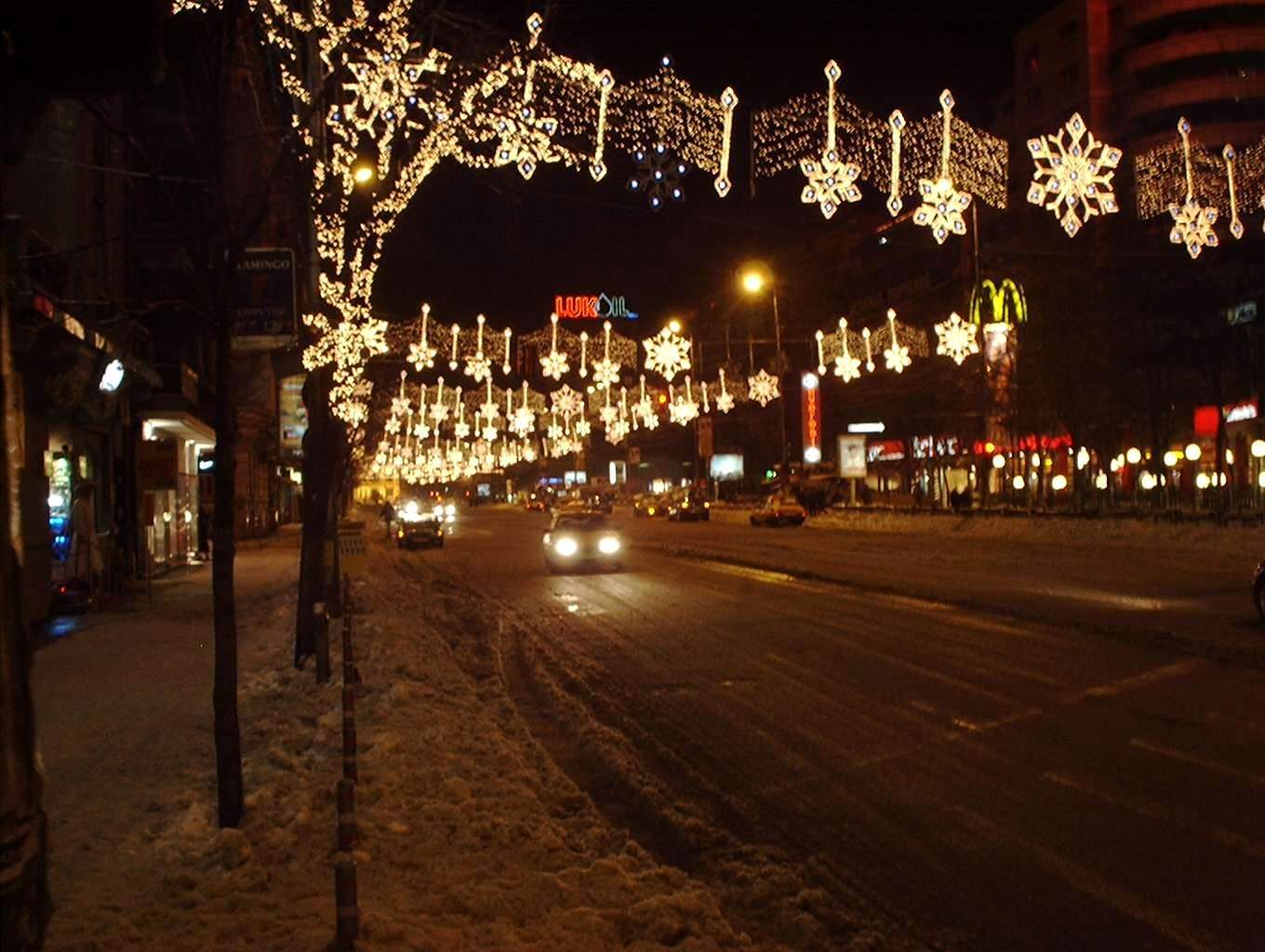 cars driving down a snowy road during the night