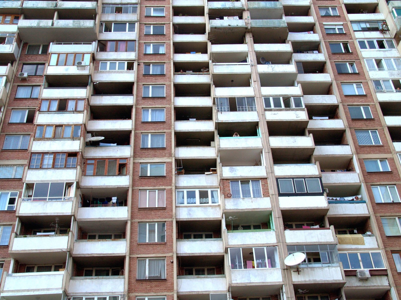 a tall brick building has many balconies in it