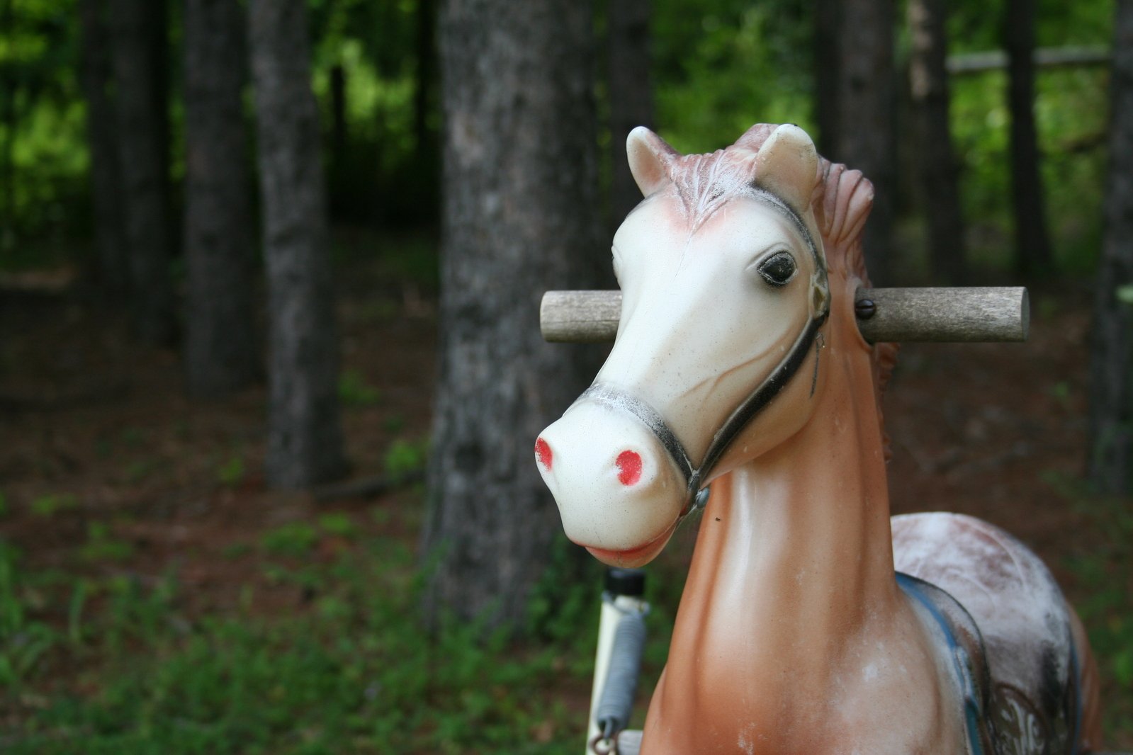 there is a horse statue outside with trees behind it