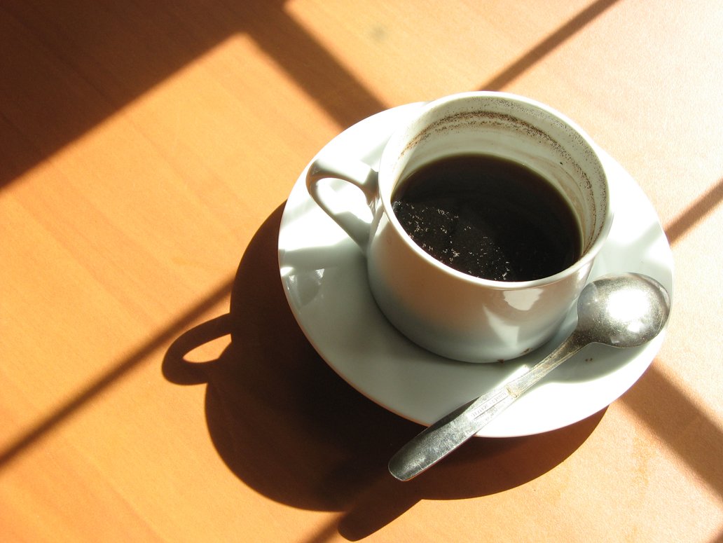 a cup on a saucer on top of a wooden table