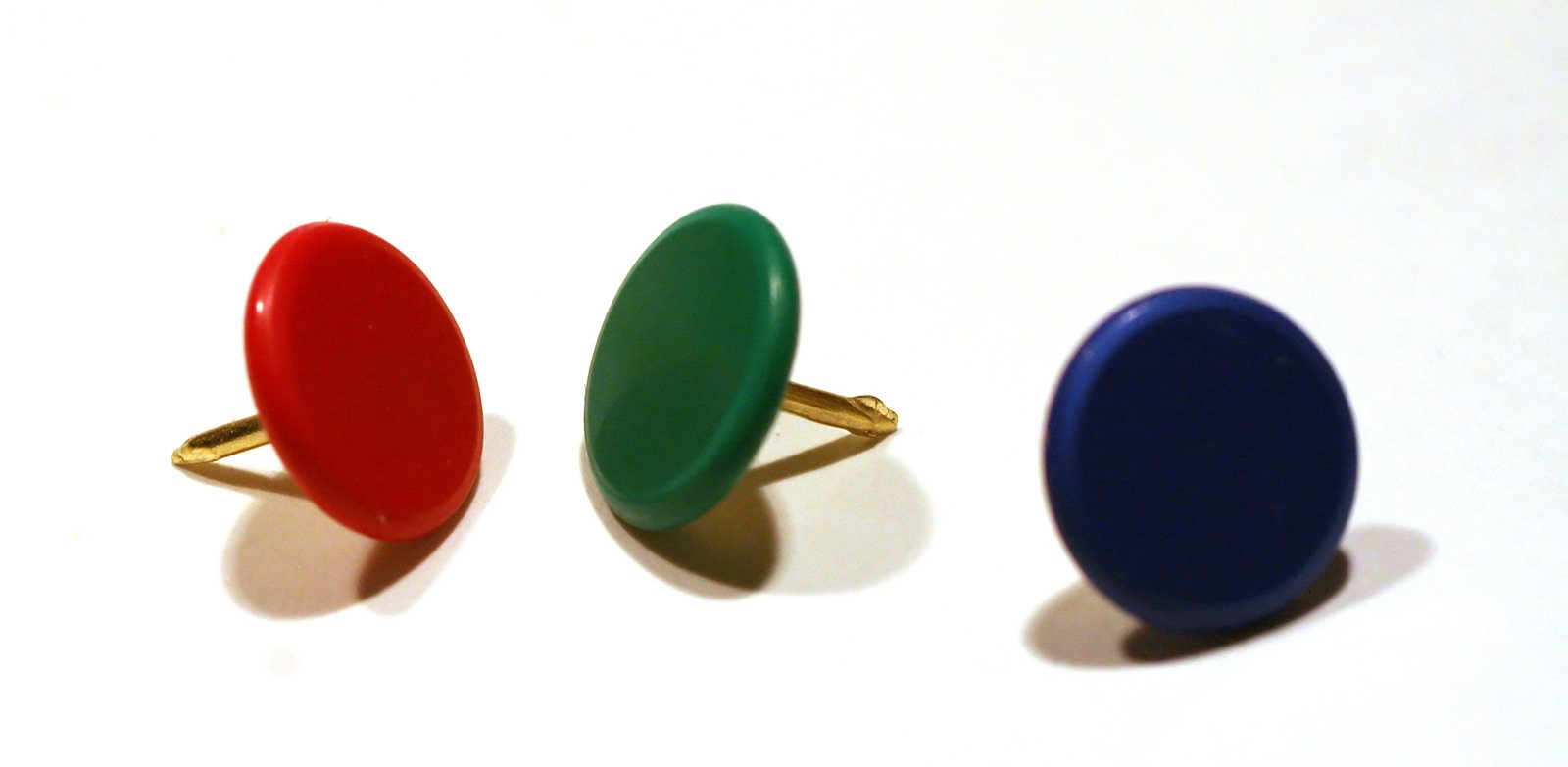 three different colors of rings sit on top of a table