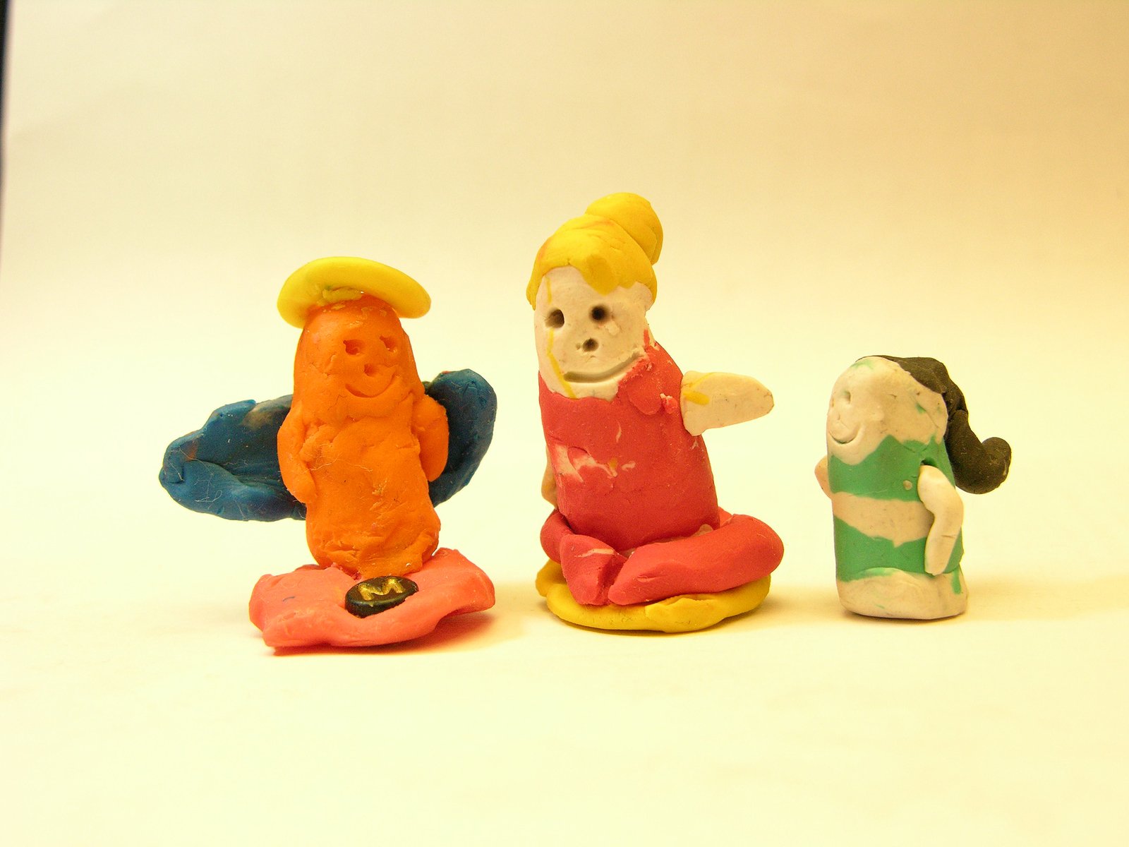 three small figurines that are all different colors