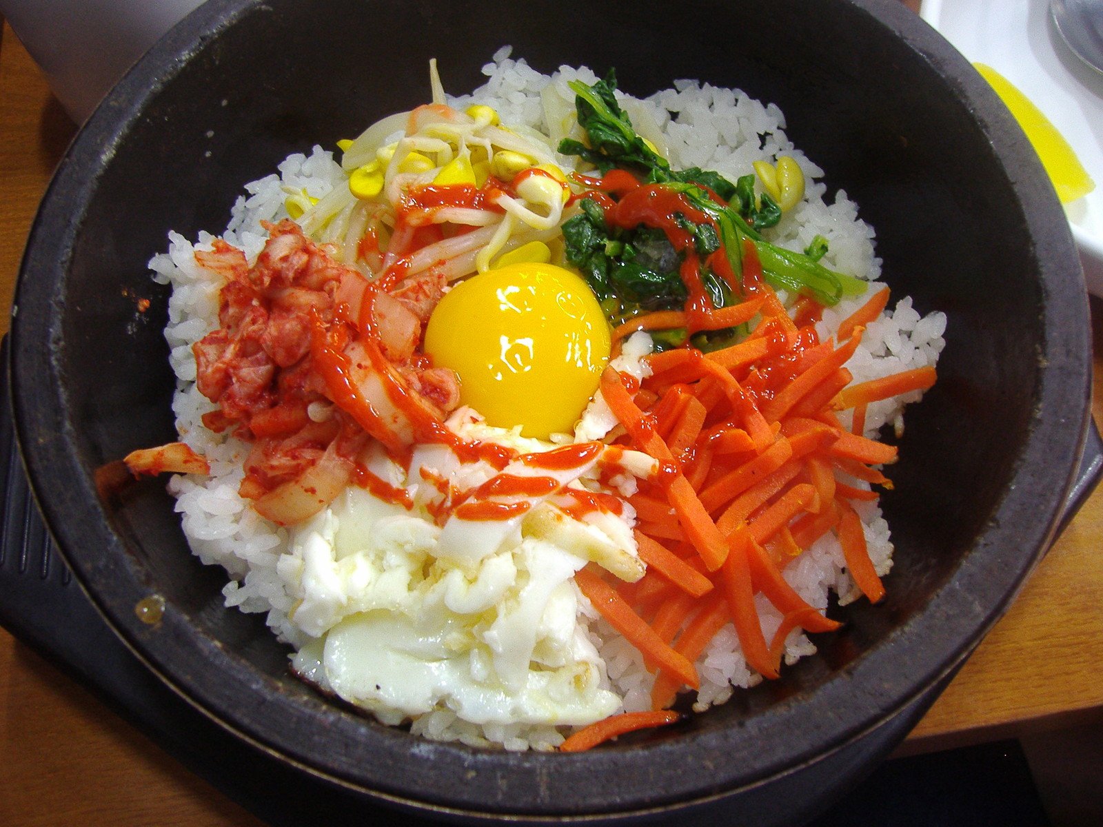 a bowl full of rice with meat and vegetables