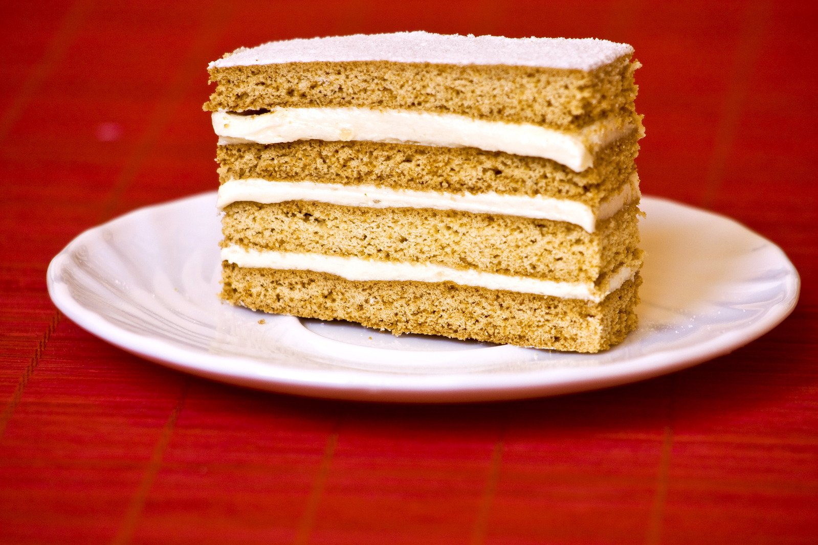 a piece of cake with white frosting sits on a plate