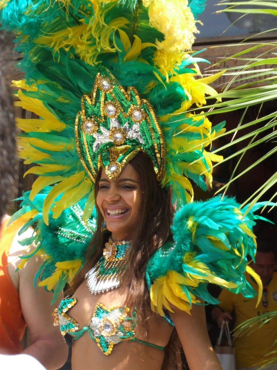 a woman in a costume wearing green, yellow and orange feathers