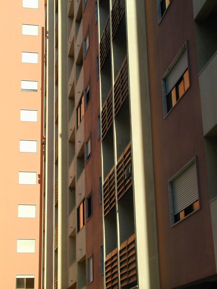 a tall brown building next to a tall red and yellow building