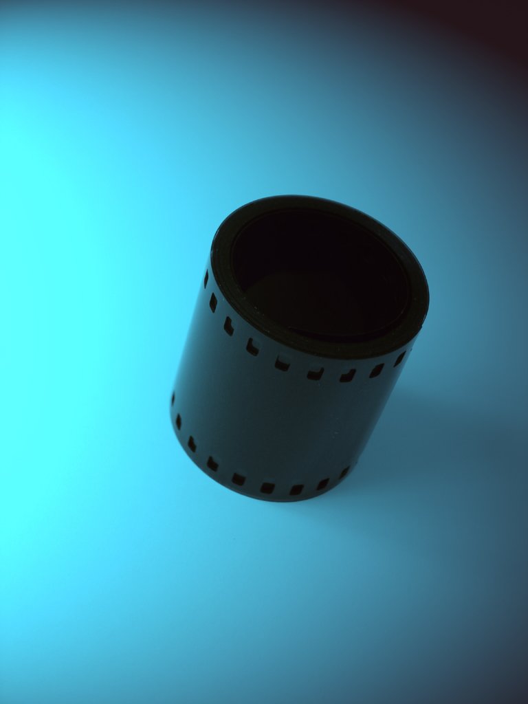 a roll of black film sitting on top of a blue floor