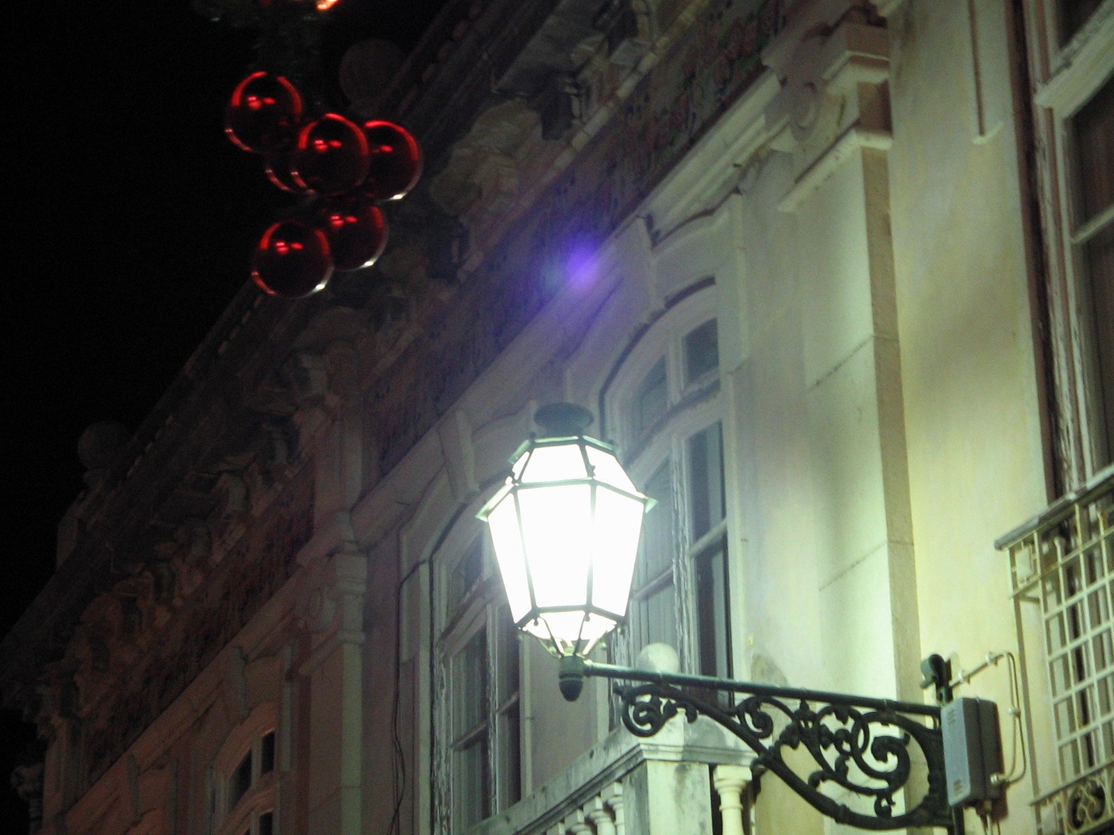 an outdoor lamp next to a building at night