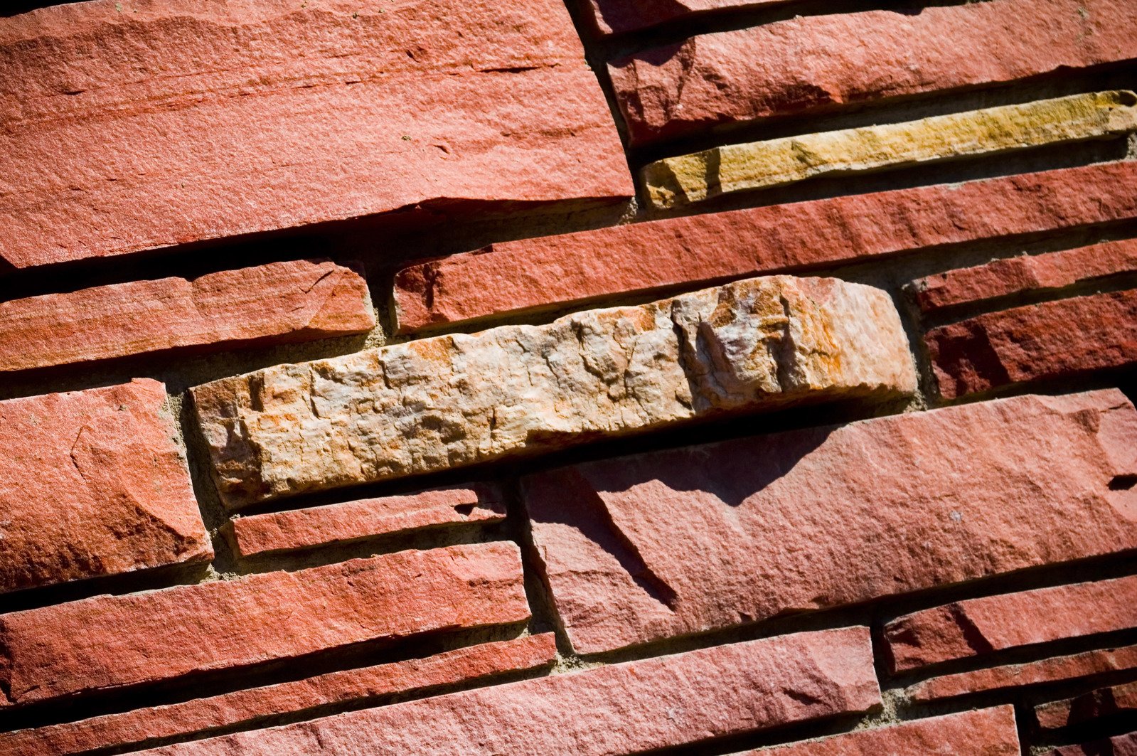 a brick wall made of blocks of red, orange, and yellow bricks