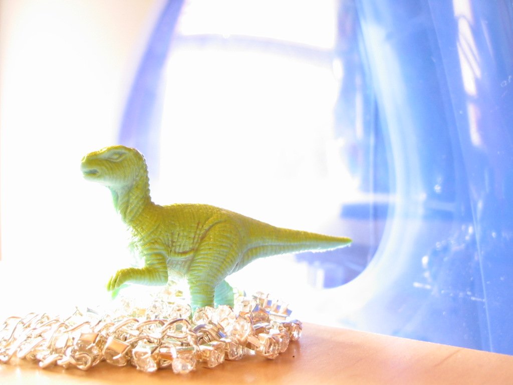 plastic dinosaur standing on tiny crystal balls on table