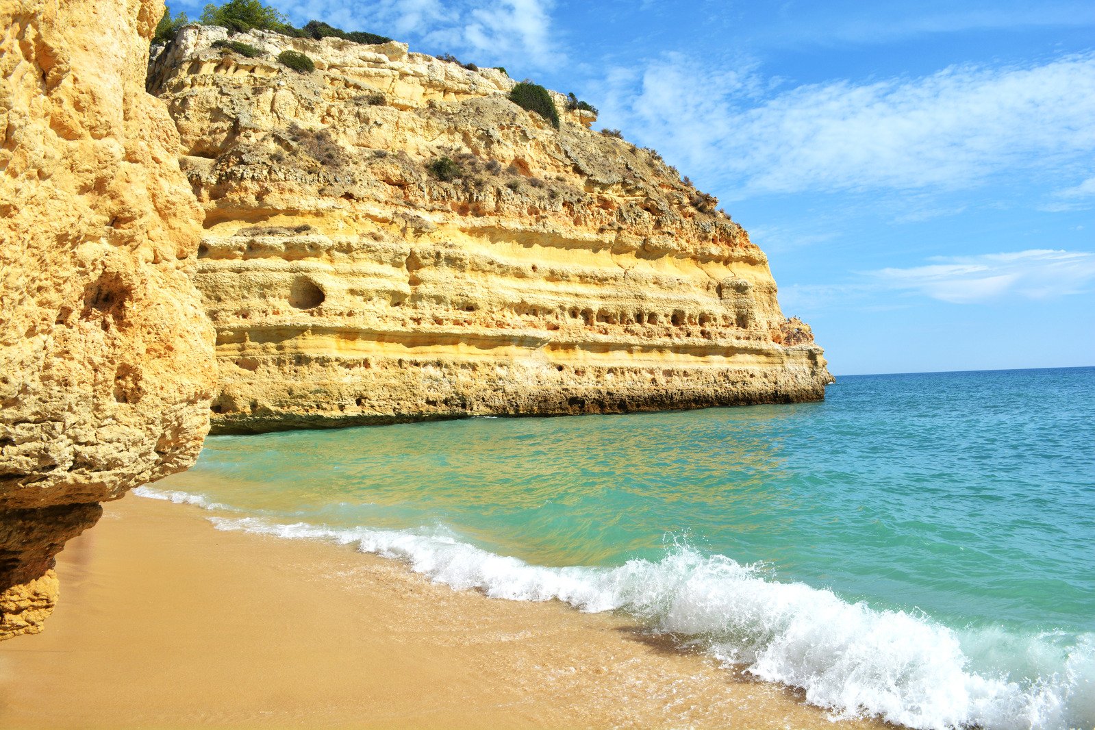 a rocky beach near the ocean in front of some cliffs