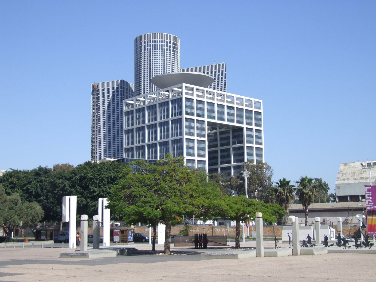 a large office building sitting behind two white pillared towers