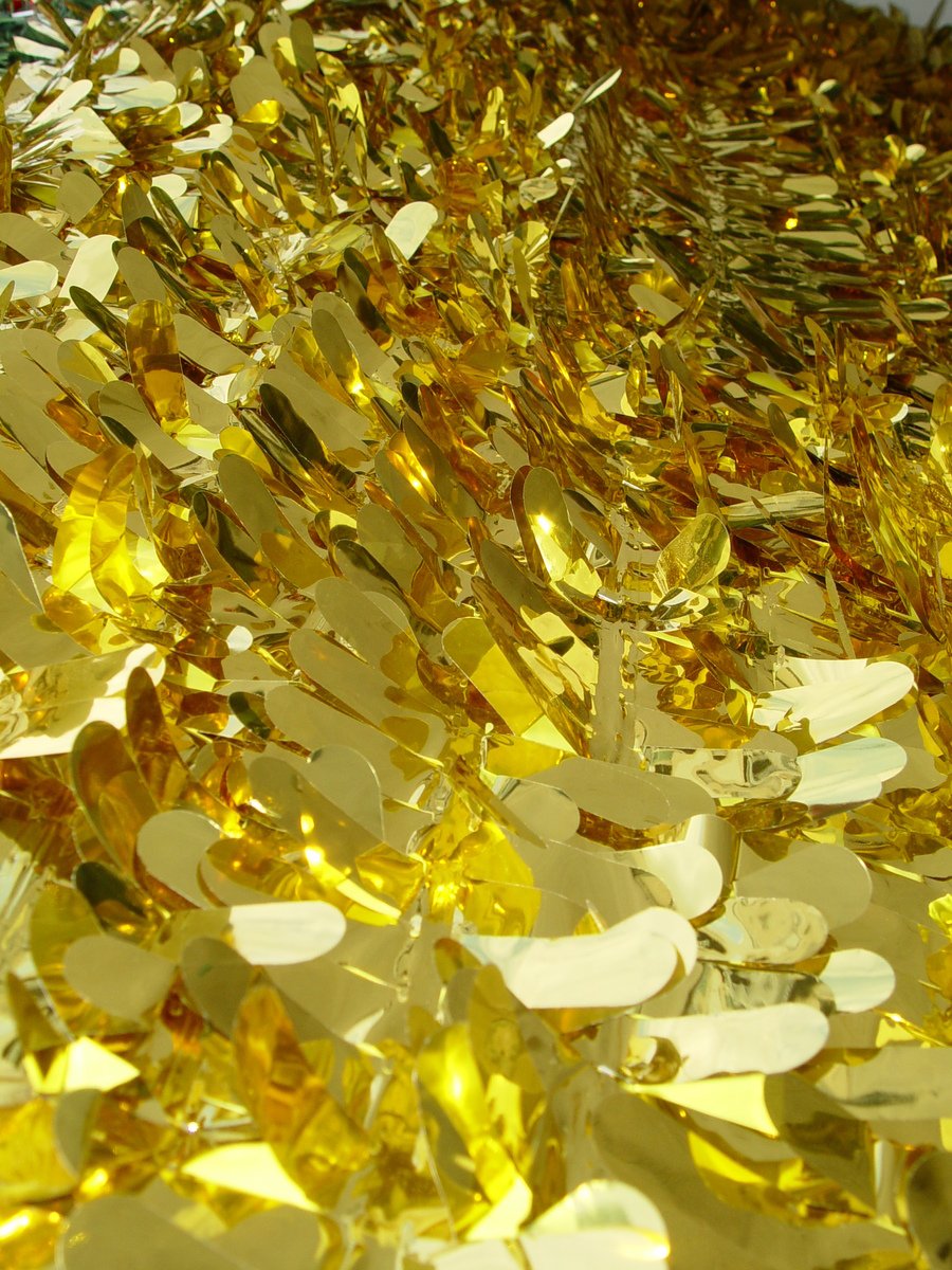 a pile of shiny pieces of yellow sequins