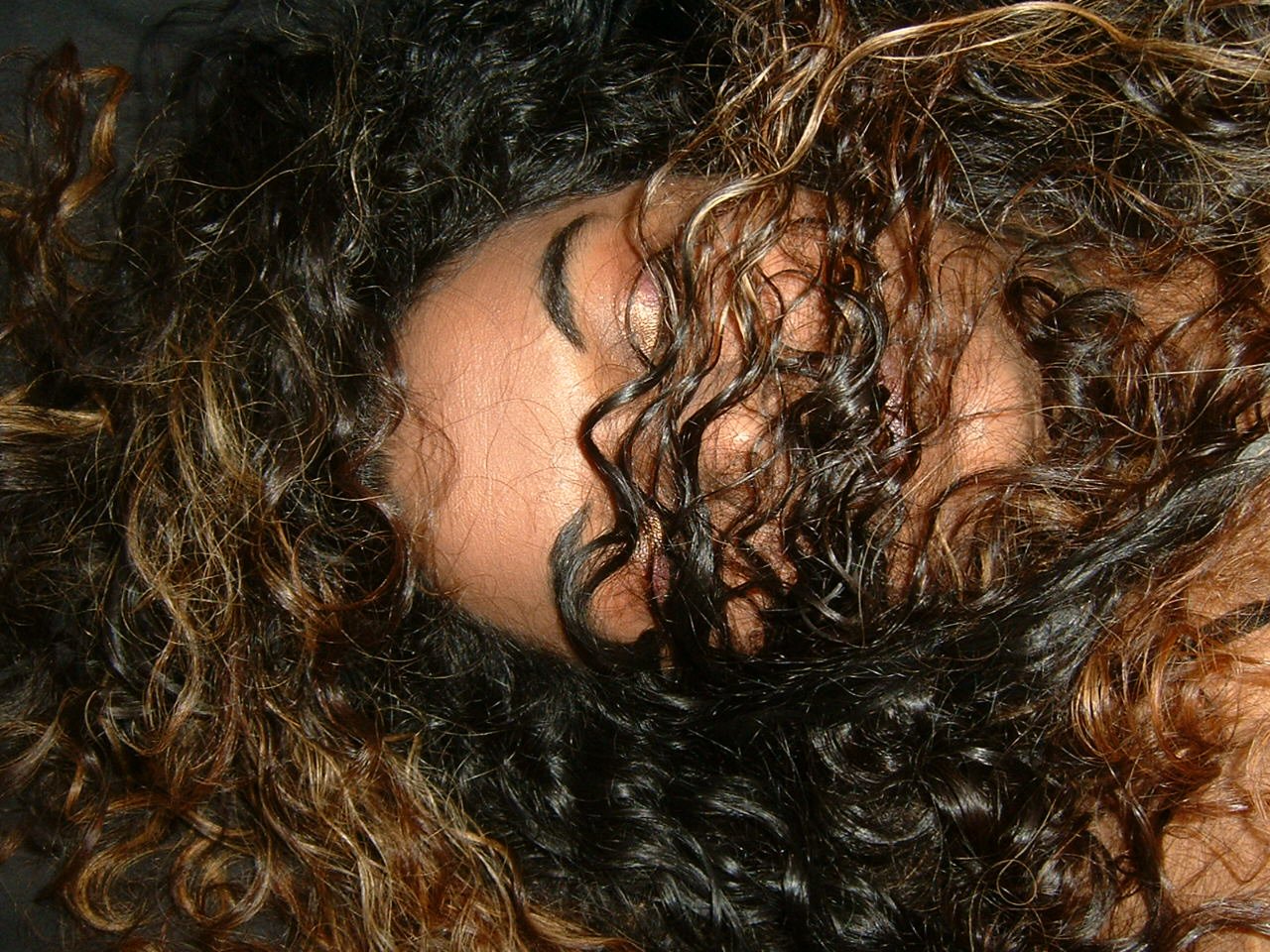 there is a young woman with curly hair laying down