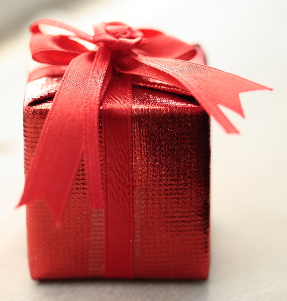 a red present box with a ribbon on it