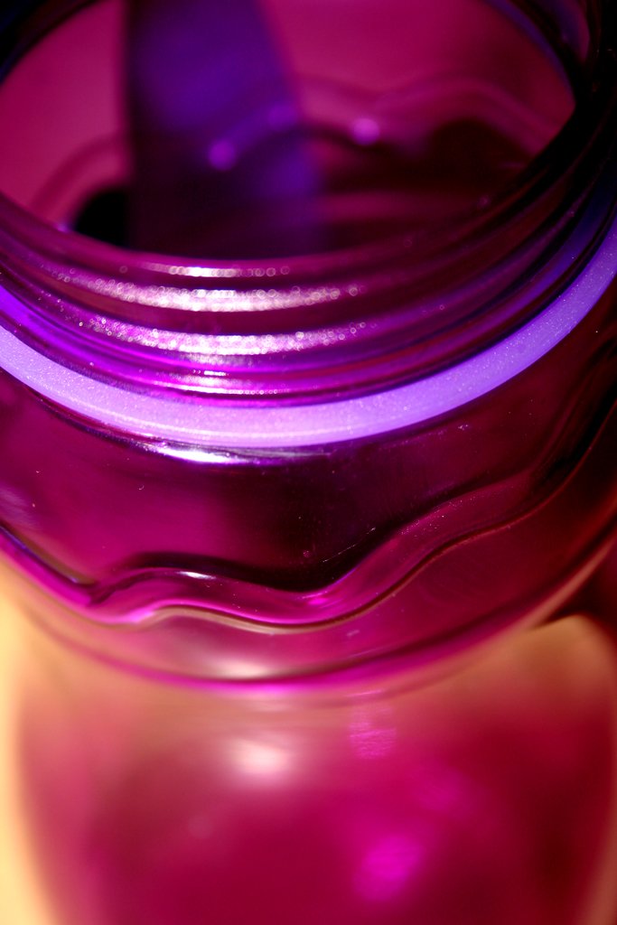 a jar that has some purple and pink glass inside