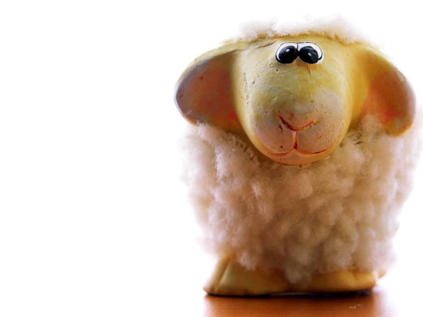 a toy sheep that has the face of a sheep covered in wool