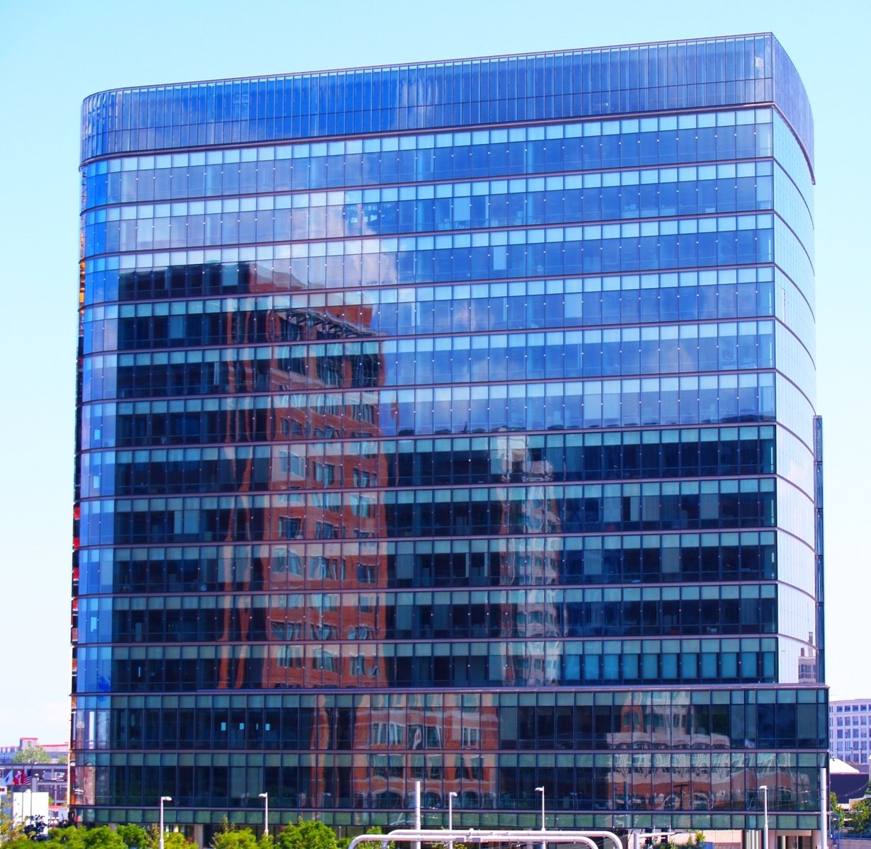 a very tall glassy building sitting above the street