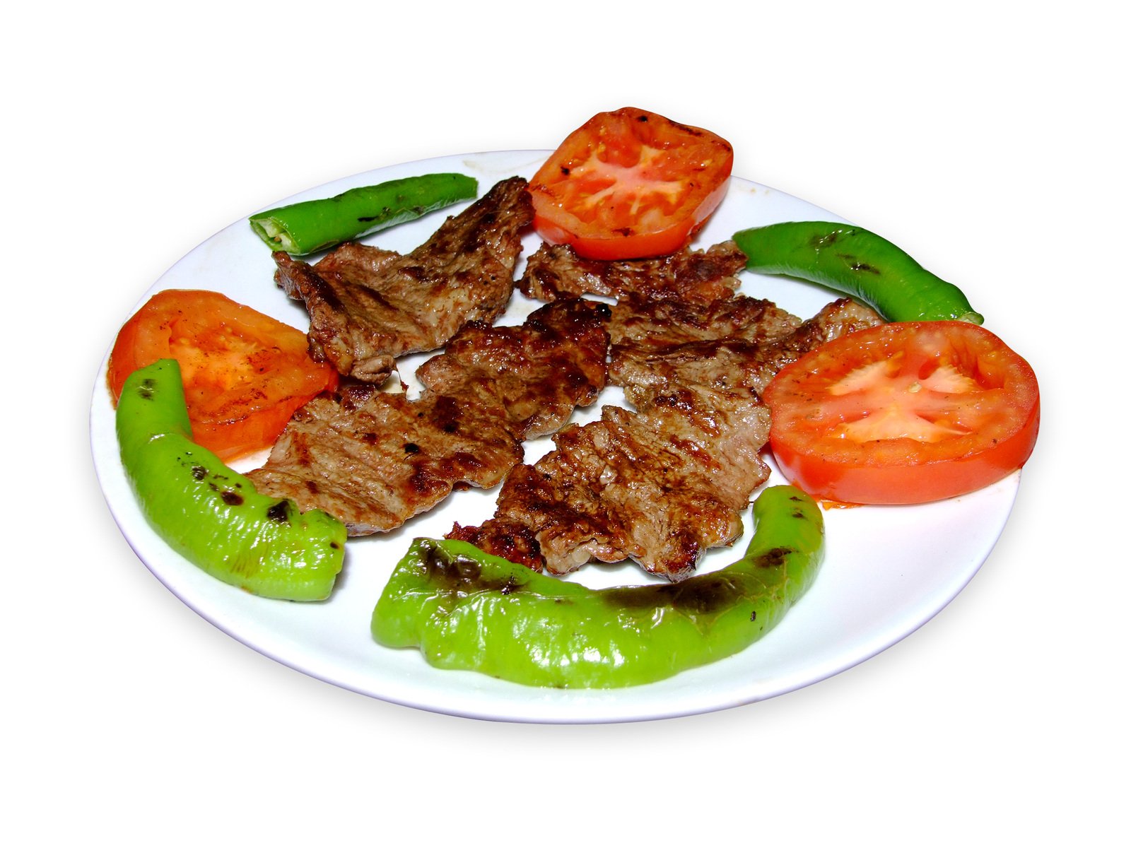 a plate of steak with tomatoes and peppers