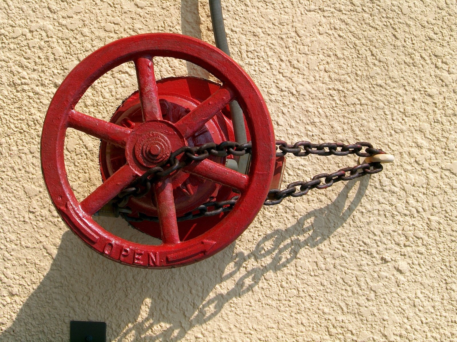 the old red fire hydrant has chain hanging from it