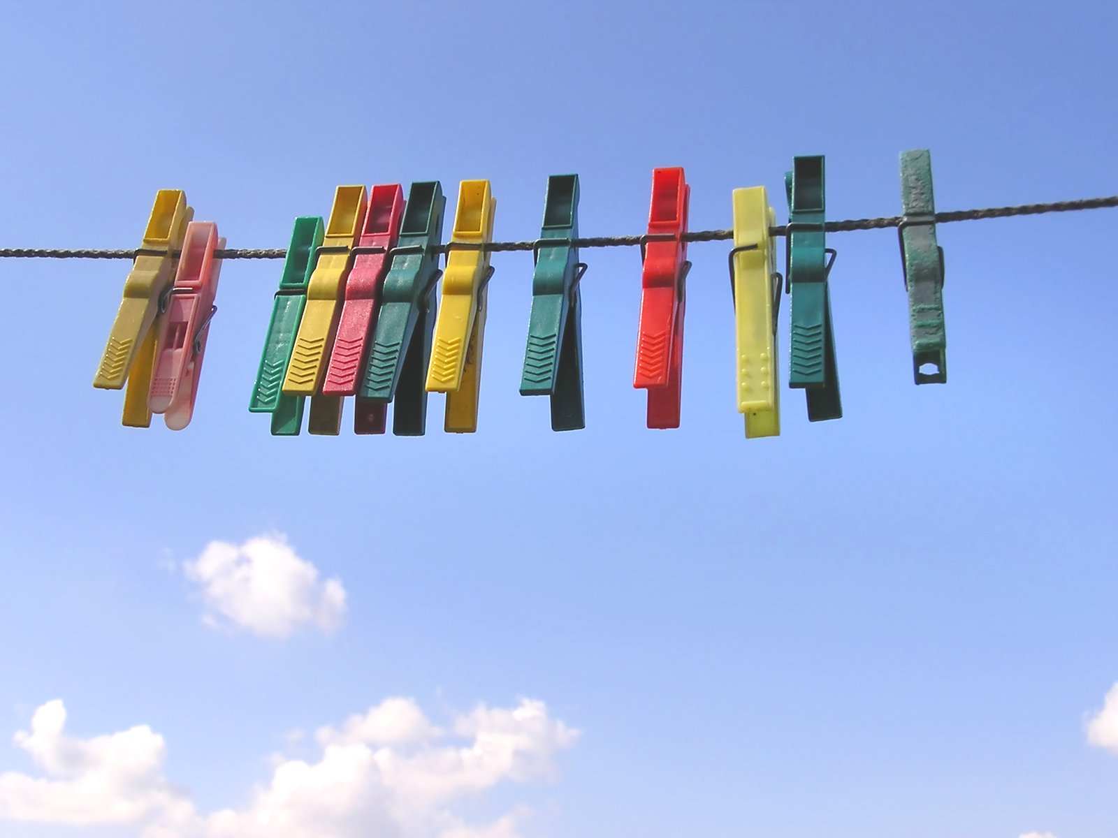 the clothesline is colorfully hung from a wire