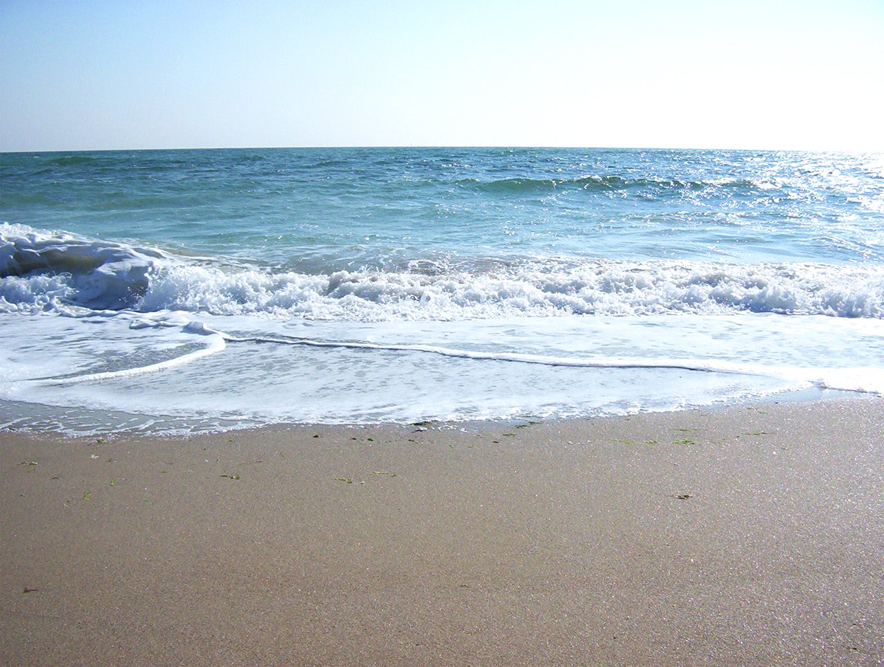 an ocean view of the blue sky and the sand