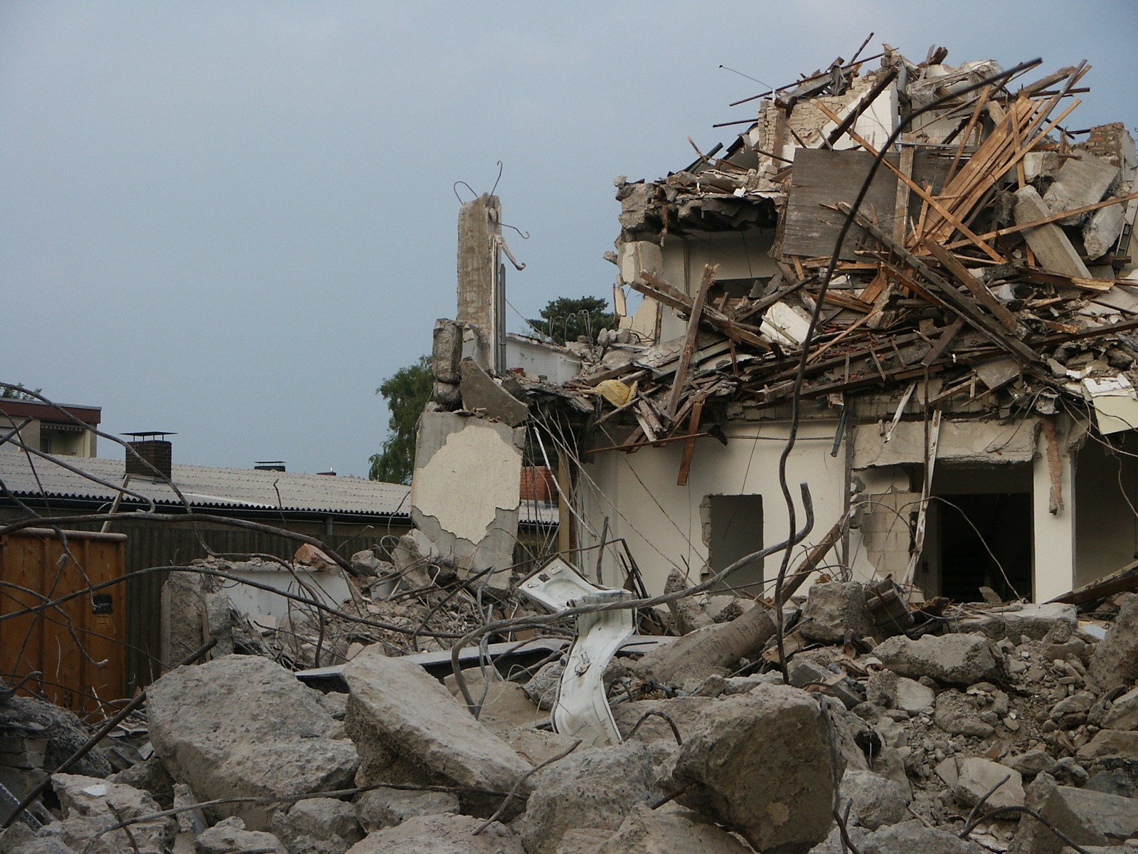 large boulders of rubble near a building on a cloudy day