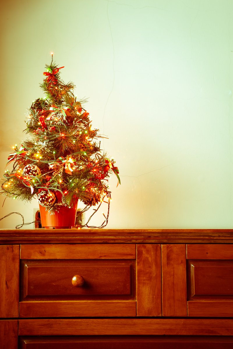 a decorated christmas tree on a dresser