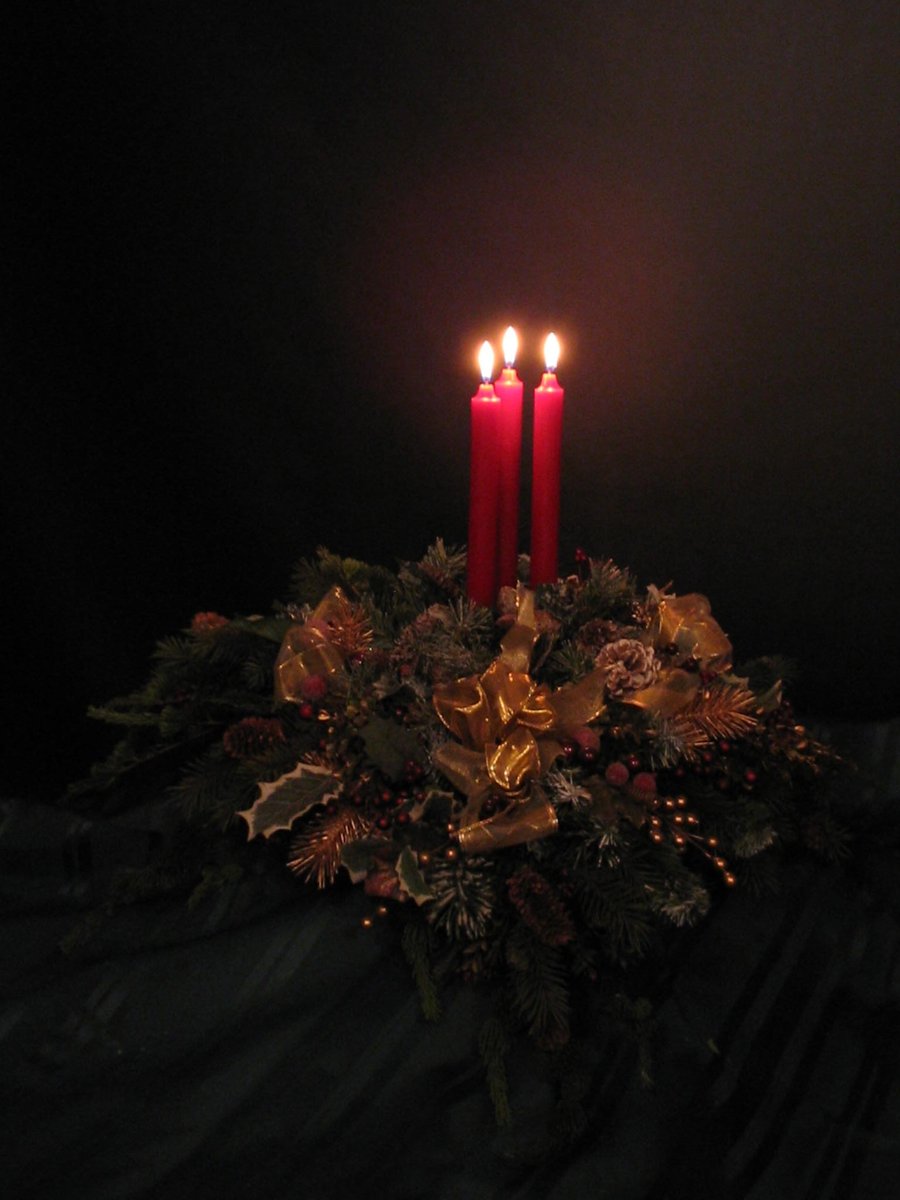 three candles are lit up on the table