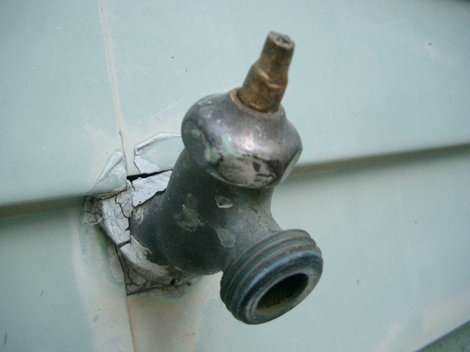 a metal bottle that is attached to a white wall