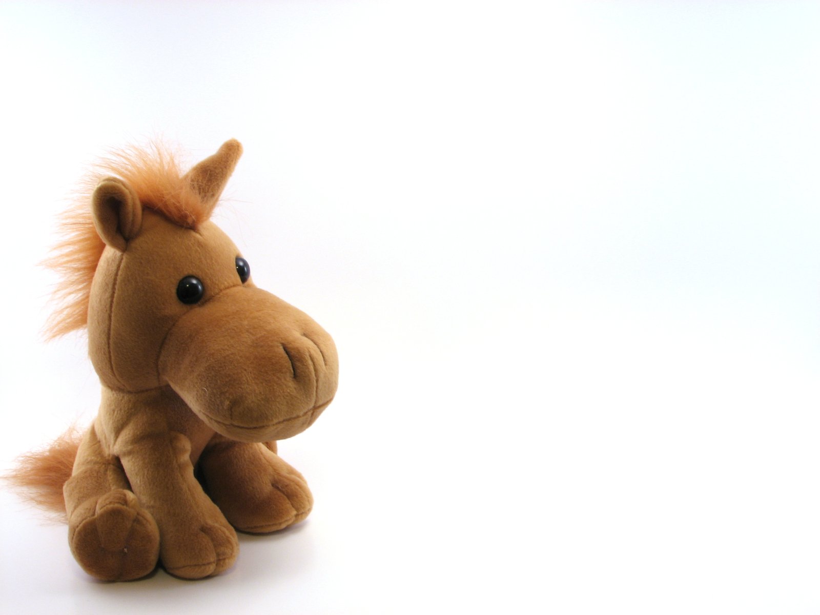 a brown stuffed animal sitting on top of a white background