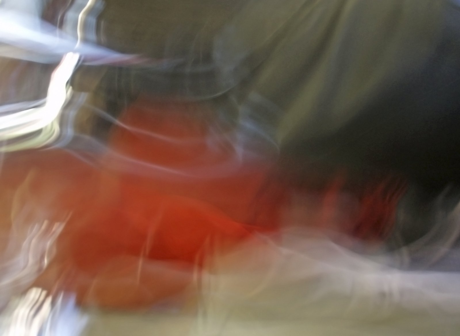blurred image of someone wearing a red shirt riding a motorcycle