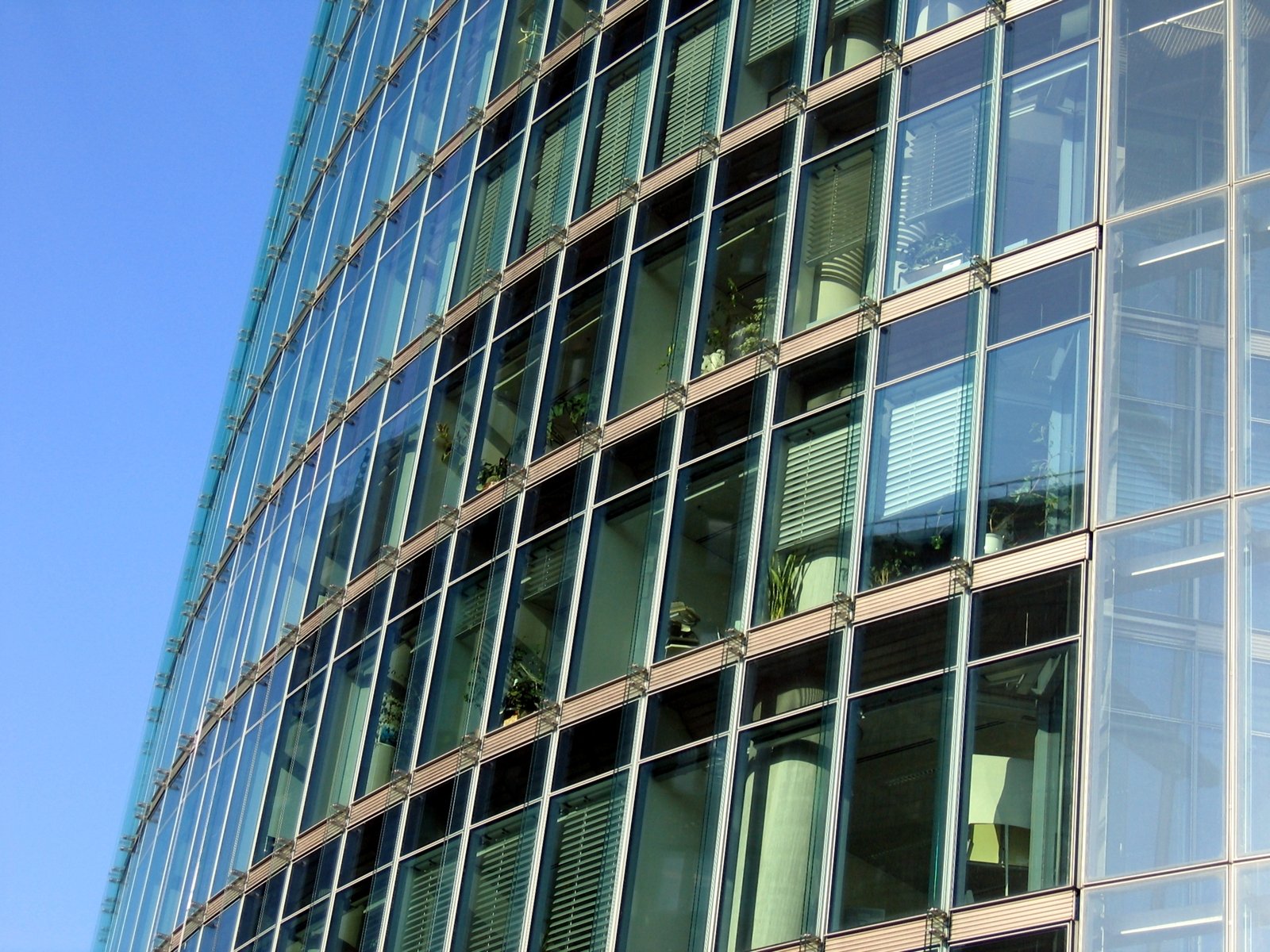 a tall glass building with several windows that are surrounded by metal bars