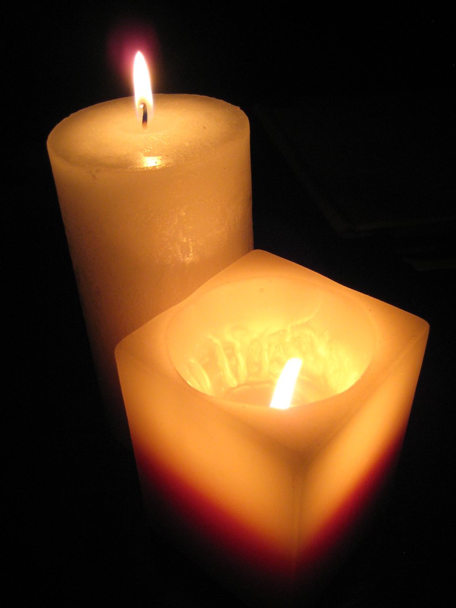 an orange candle that is lit up in the dark