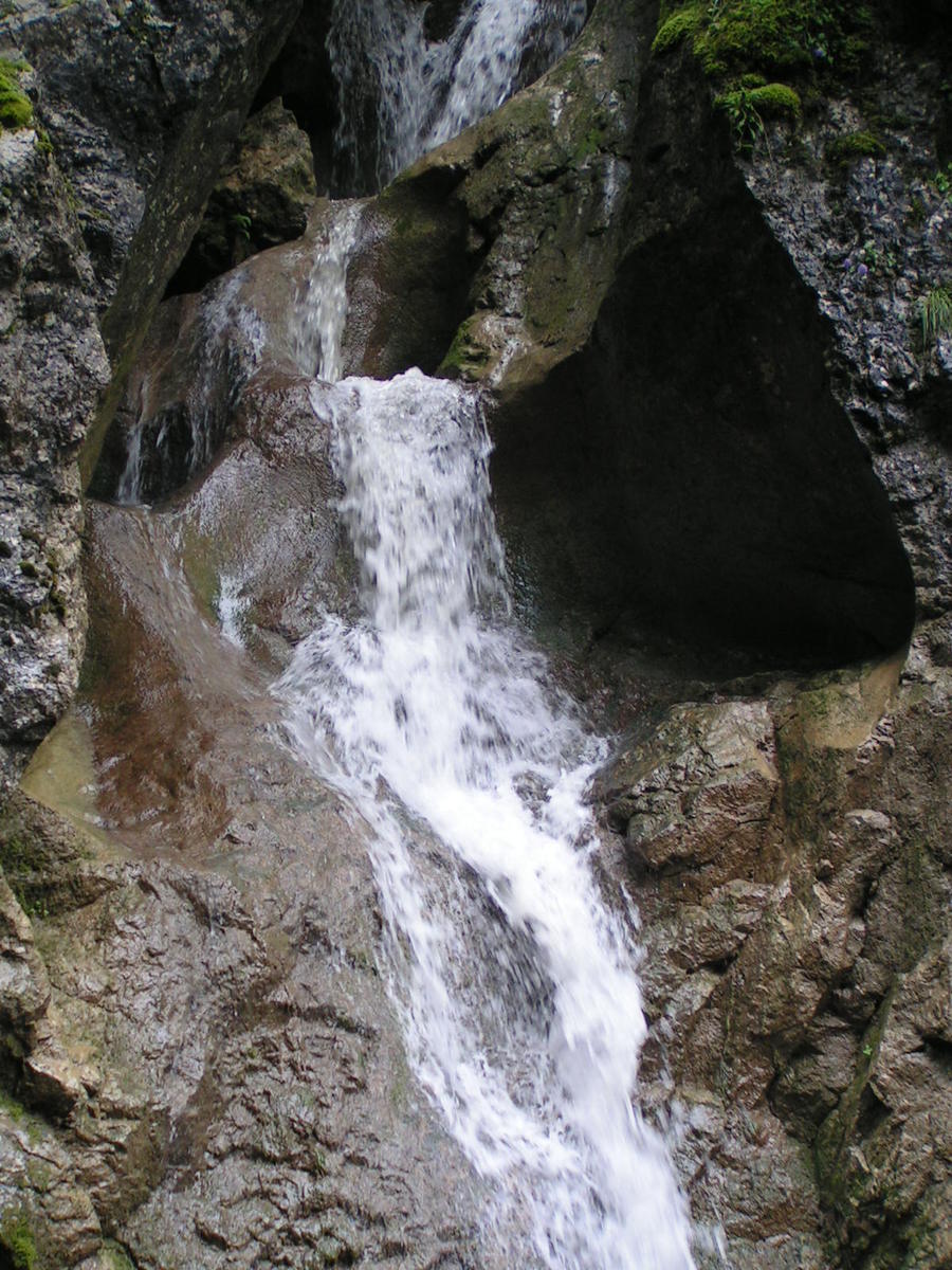 there is a waterfall that is pouring down the side of the rock