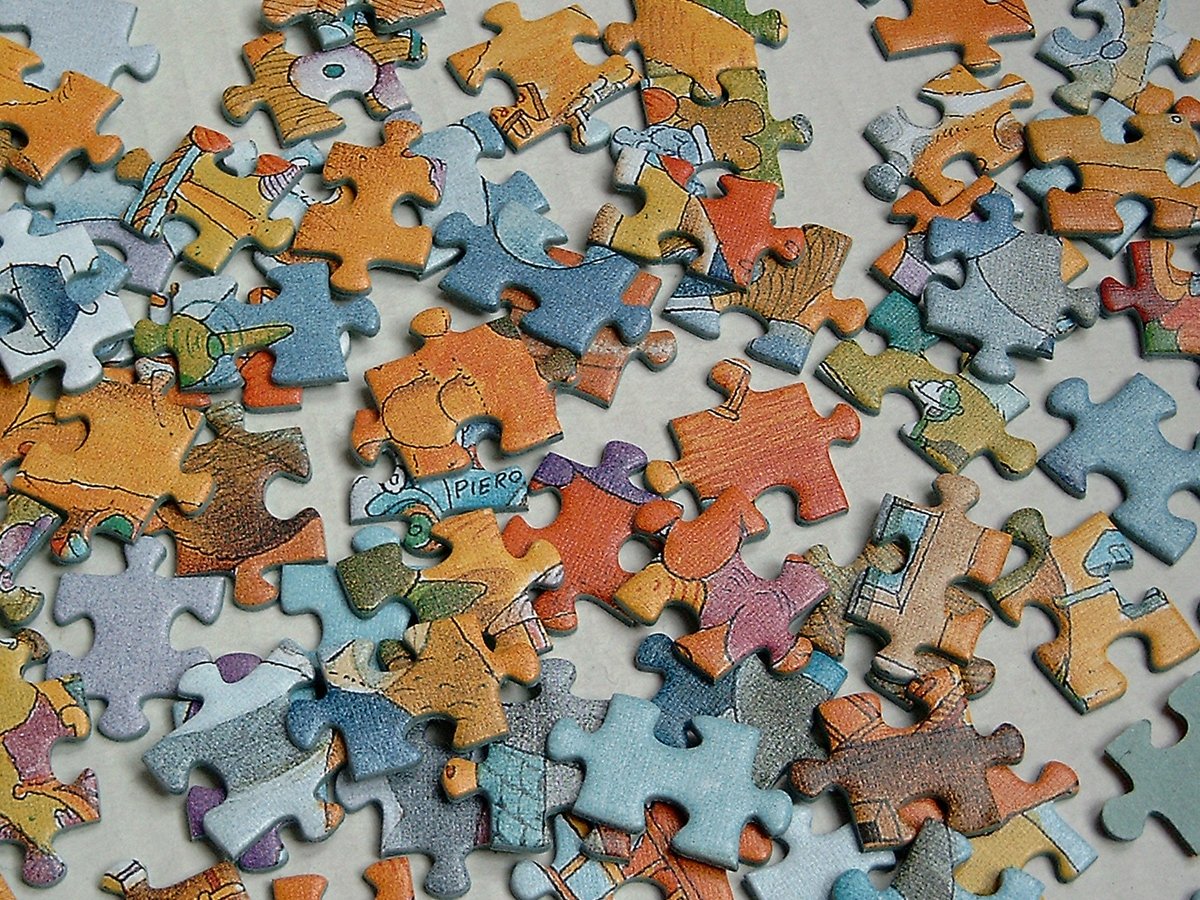 large assortment of colorful jigsaw pieces sitting on top of a table