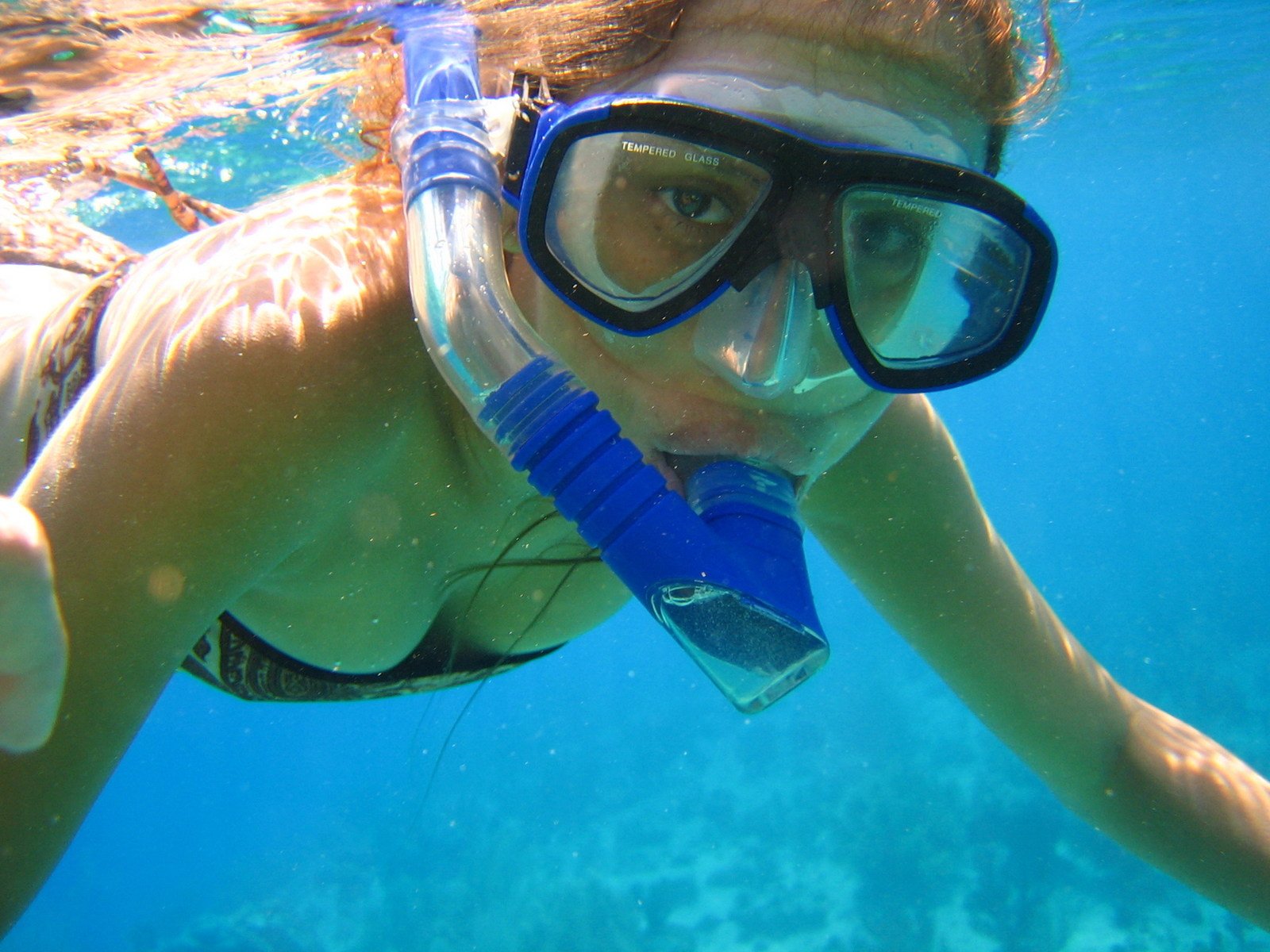 a person wearing goggles swimming in the water